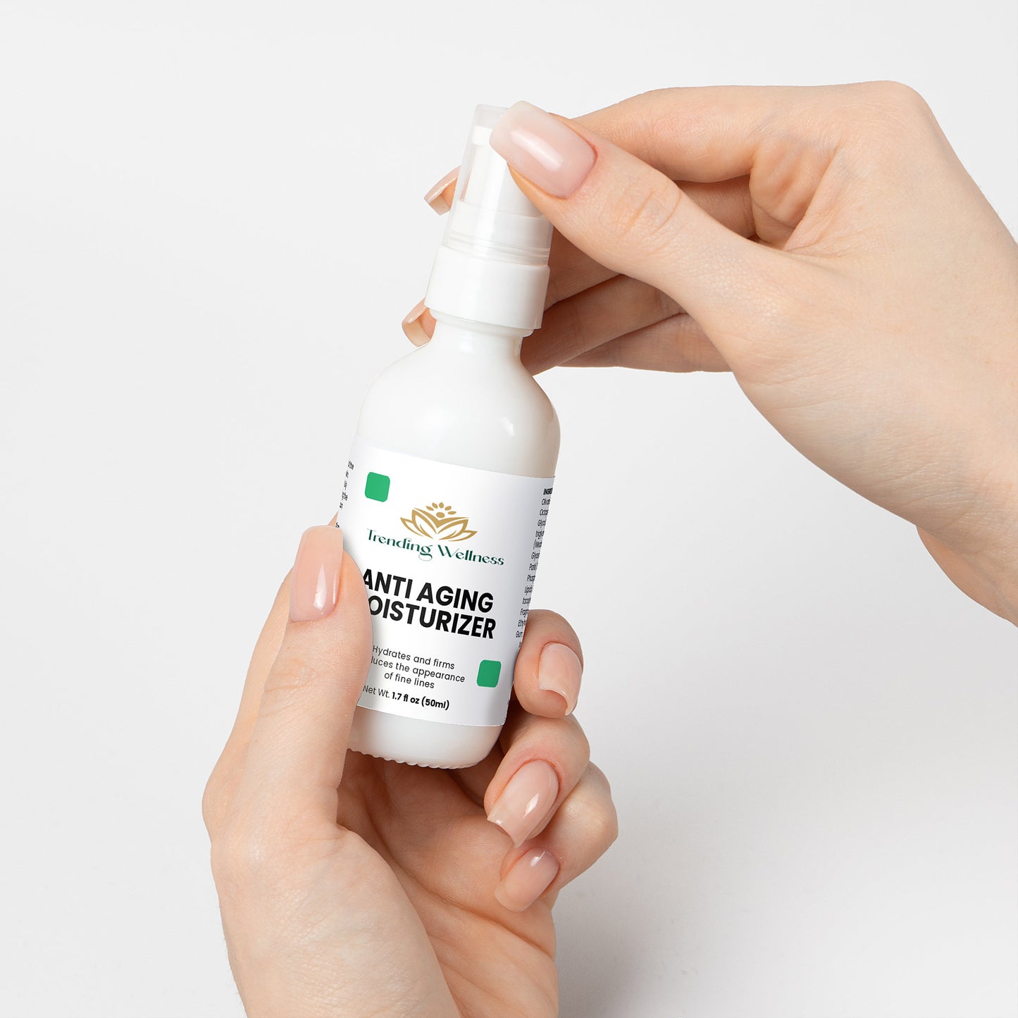 Hand holding a bottle of anti-aging moisturizer against a white background