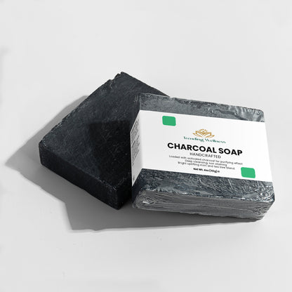 Black charcoal soap bar with a white label on a light gray background