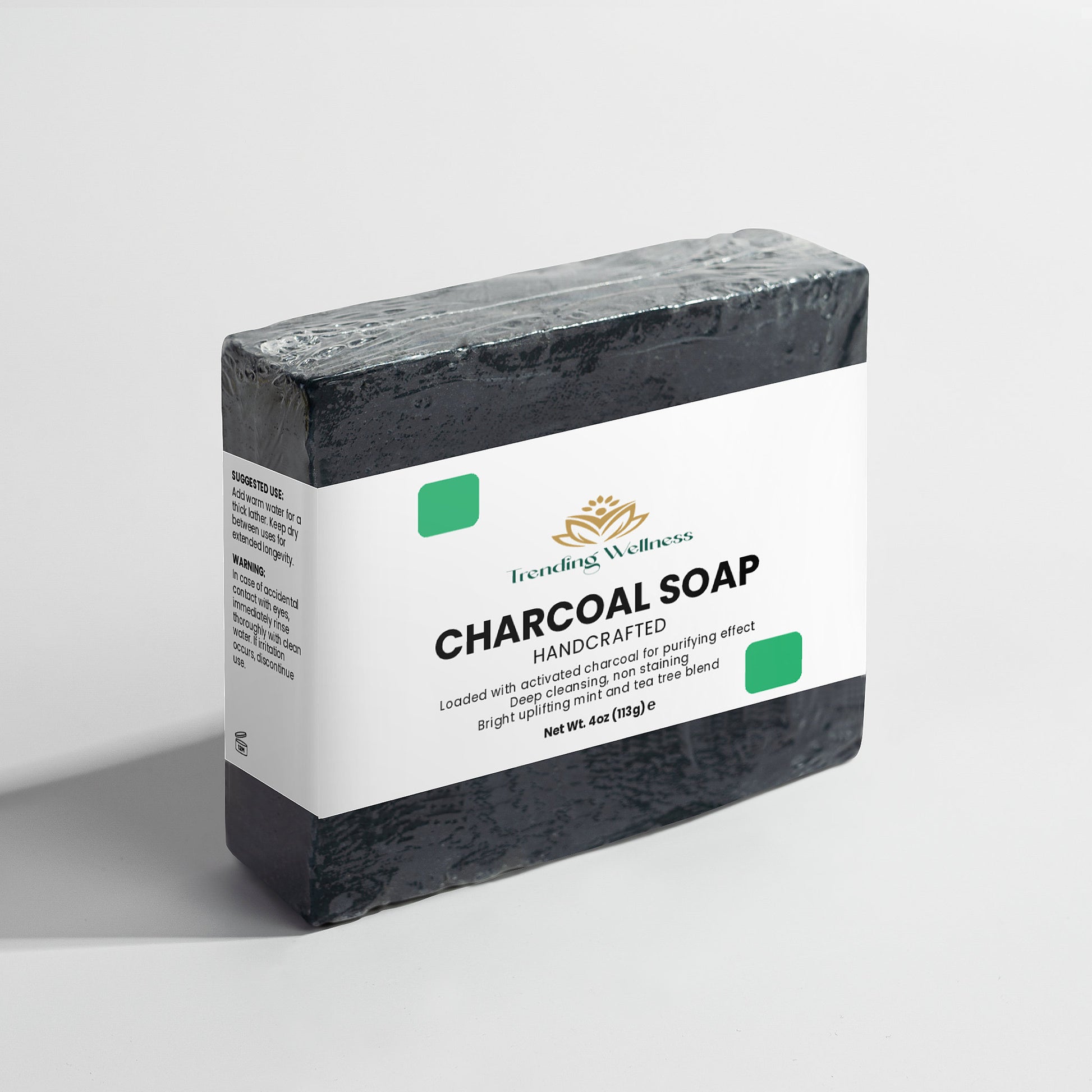 Bar of charcoal soap with a white label on a light gray background