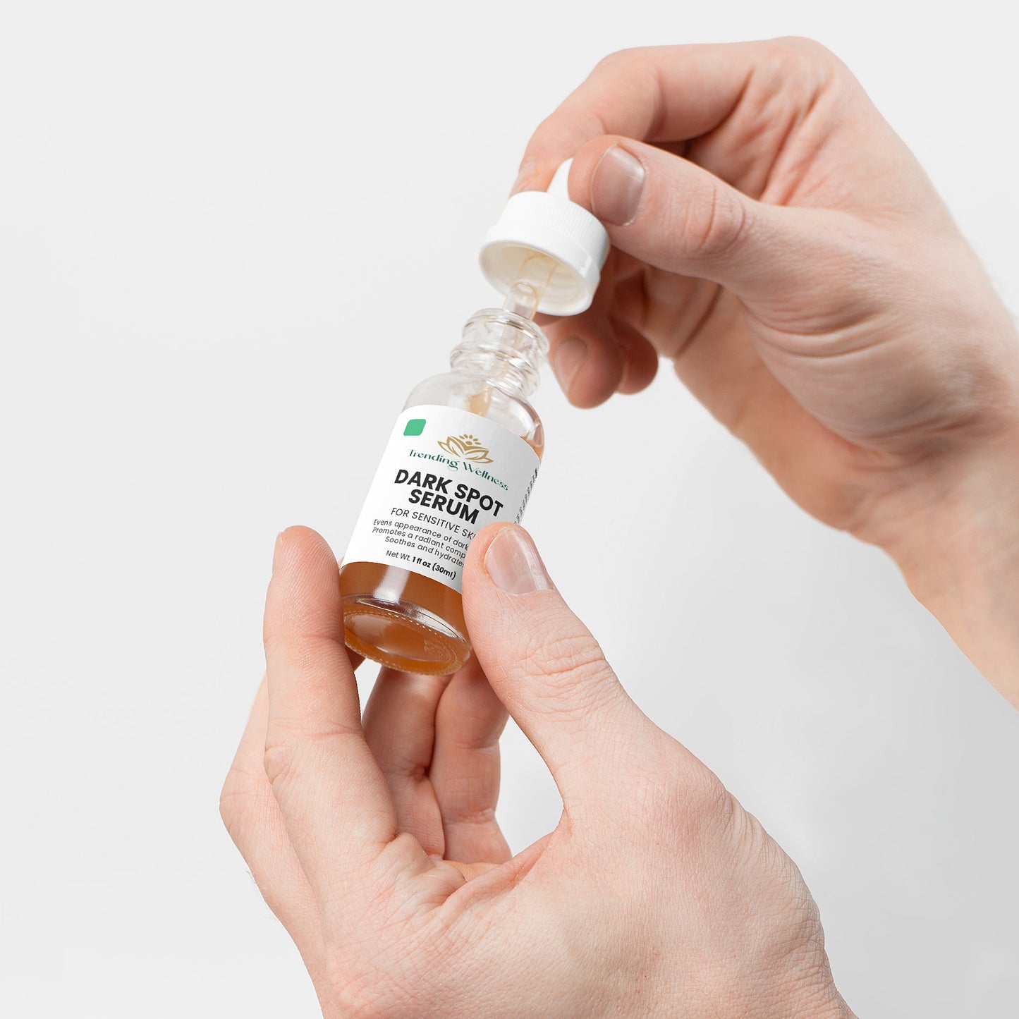 Hand holding a dropper bottle of A. Soluna Dark Spot Serum against a light background