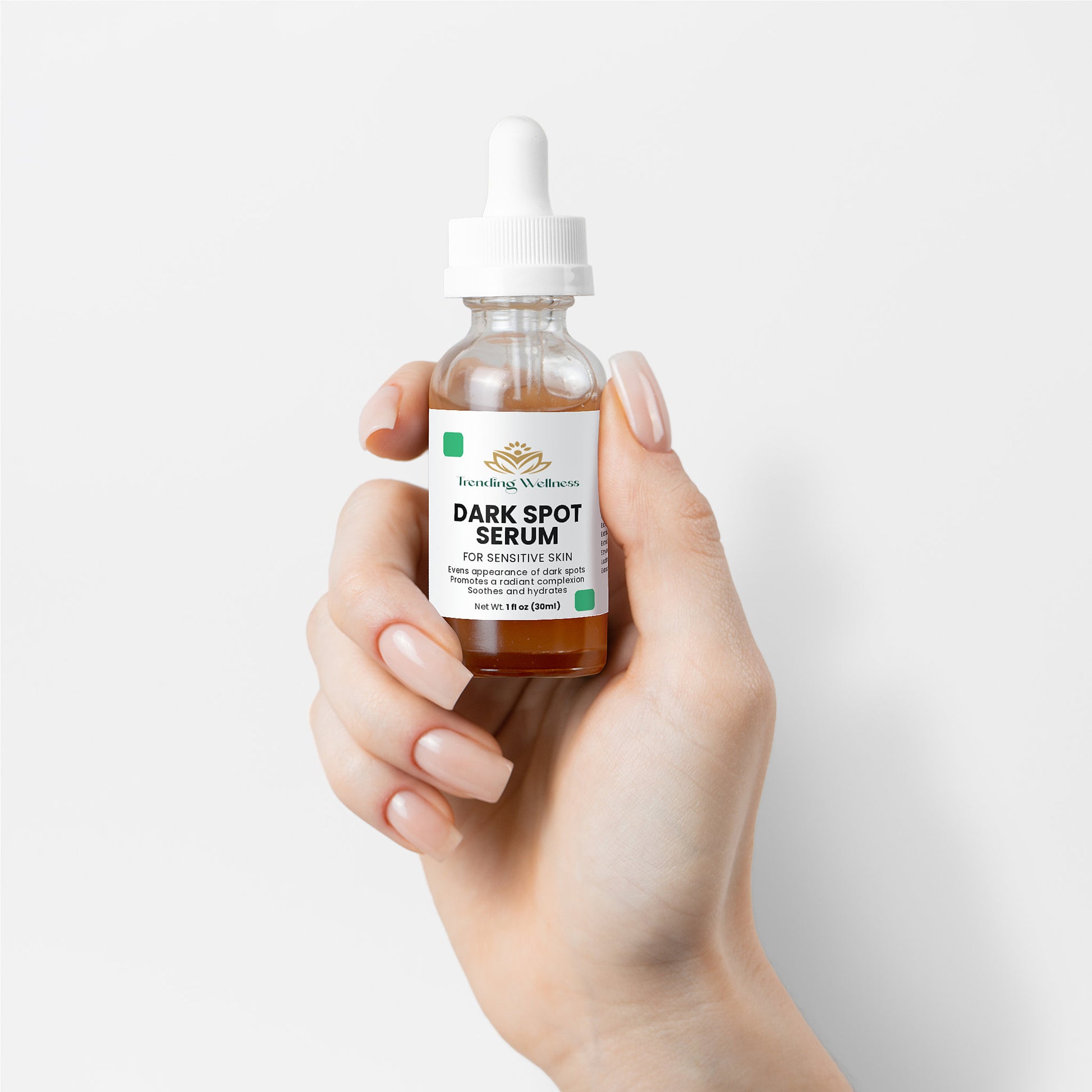 Hand holding a bottle of dark spot serum with a white background