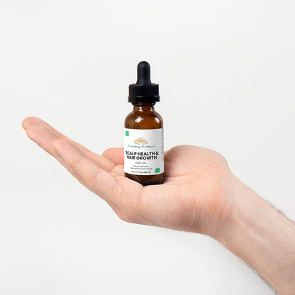 Hand holding a bottle labeled 'Scalp Health & Hair Growth' against a white background