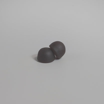Two gray earbuds on a light gray background