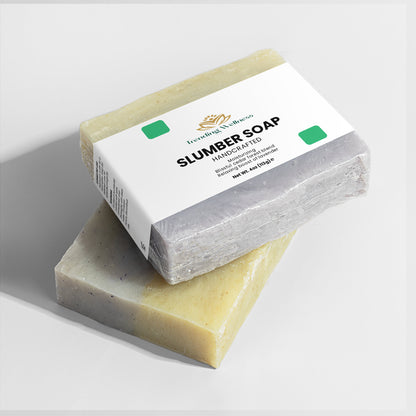 Two bars of soap with a box labeled 'Slumber Soap' on a light gray background